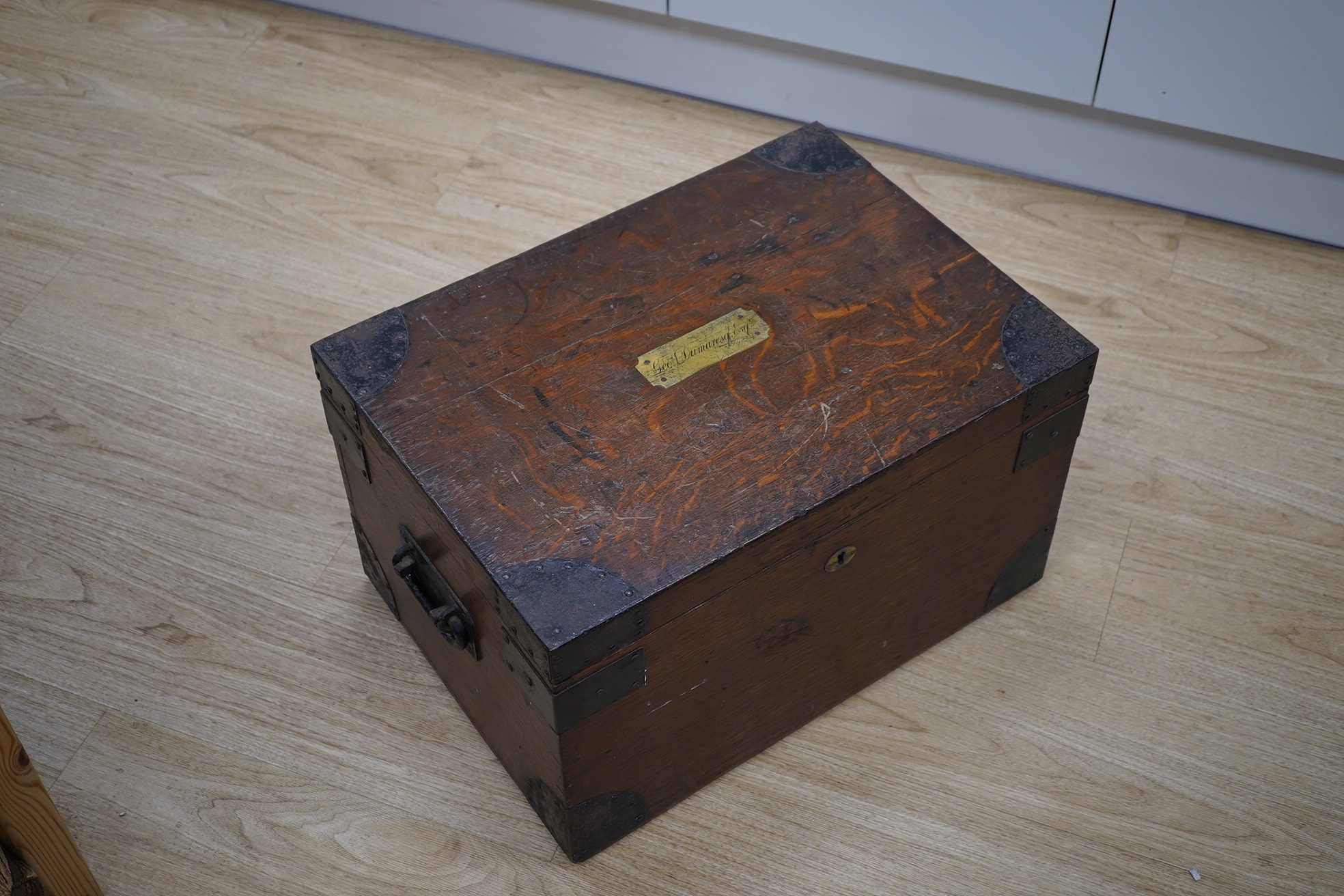 A 19th century wrought iron bound oak canteen, brass plaque inlaid to lid reads ‘Geo: Dumaresq. Esq’, 52cm wide. Condition - fair